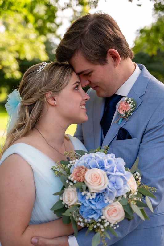 Ein Hochzeitspaar steht dicht beieinander und schaut sich verliebt in die Augen.