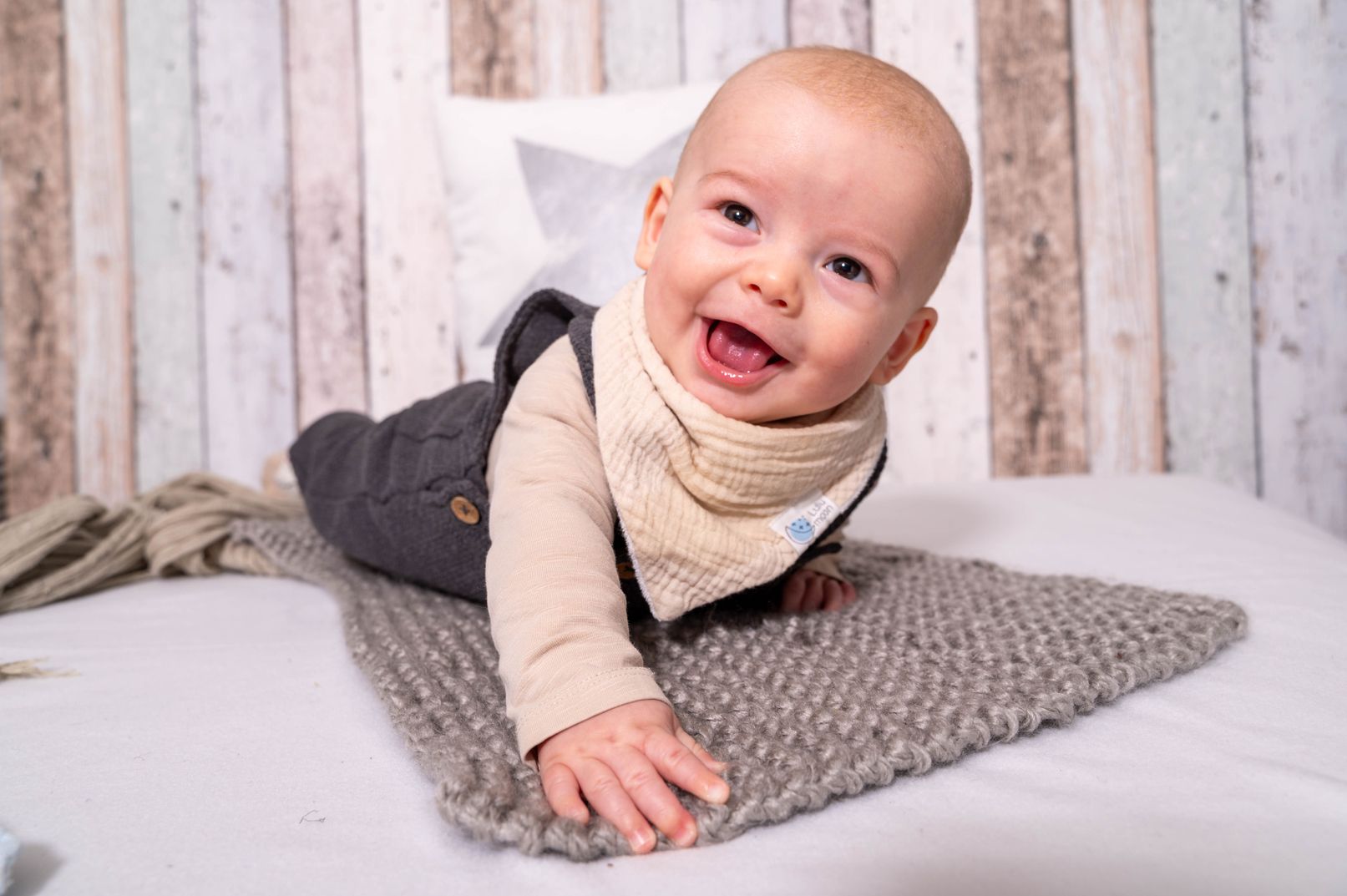 Kind, das auf einer weichen Wolldecke liegt, mit einem entspannten und glücklichen Gesichtsausdruck