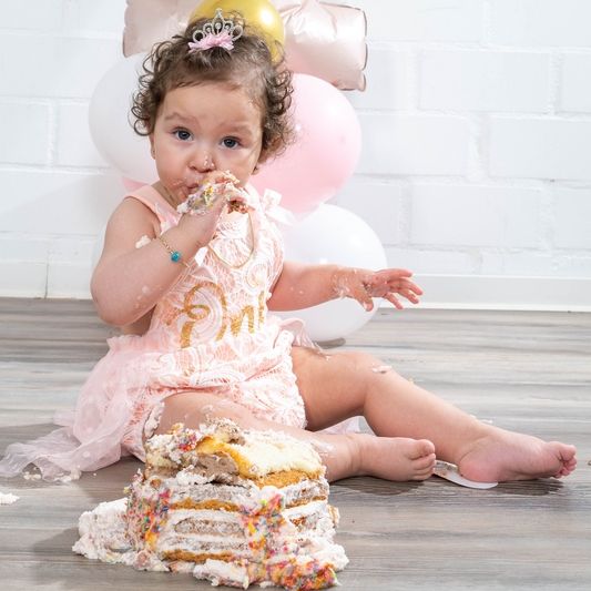 Ein Kind sitzt und isst eine Pause, möglicherweise ein Sandwich oder einen Snack. Die Szene wirkt alltäglich, mit einem Fokus auf das Kind, das genussvoll seine Mahlzeit zu sich nimmt. Im Hintergrund könnten weitere Details einer Schule, eines Pausenplatzes oder eines Innenraums erkennbar sein.